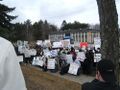 Crowd shot with signs and church.