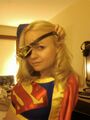 Steampunk Supergirl. Or, to give her her real name, 'Regular Supergirl Wearing A Retarded Eyepatch With Watch Parts Glued Onto It'.